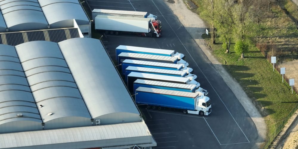 Aerial view of goods warehouses and logistics center in industrial city zone from above.